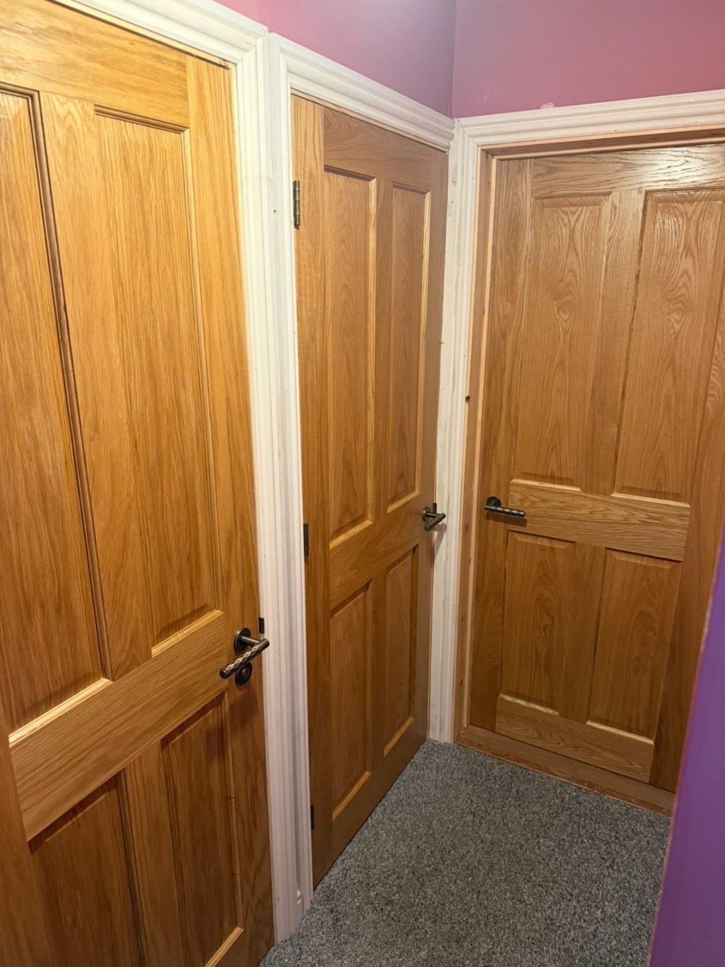 Solid oak six-panel doors with dark handles